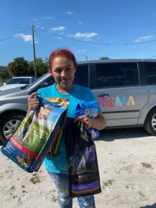Immokalee parent Maria Lozano receives pet food from Gulf Coast Humane Society