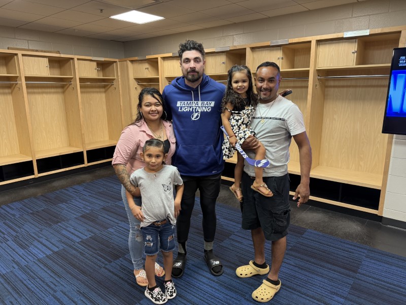 RCMA members meet Tampa Bay Lightning player Nick Paul in the locker room during Noche Latina at Amalie Arena, celebrating Hispanic culture and community.